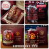 Four different Manchester United 148th anniversary glasses shown with ice and boxed sets, set against stadium backgrounds and luxurious wood surfaces.
