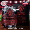 Manchester United 148th anniversary Style 2 glass with intricate detailing of Old Trafford and historical club info, filled with ice and placed in a stadium setting.