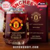 A Manchester United 148th anniversary collector’s glass filled with ice, front-facing with sharp detail on the logo and gold foil art.