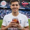 Man in Tottenham Hotspur shirt holds Manchester United 148th anniversary glass with ice and red drink, featuring the club crest and stadium detail!