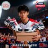 Athlete holding Ole Miss sneakers in stadium.
