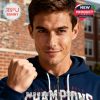 Male model wearing a navy blue Ole Miss Champions hoodie with bold front graphics standing outdoors near a brick building!