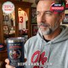 Hand holding Ole Miss Sugar Bowl tumbler with red handle and football background.