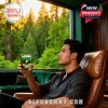 Man seated indoors holding Oregon Ducks glass with forest view through window