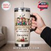 Hand holding Peanuts anniversary tumbler with handle and straw.