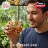 A man enjoying a detailed Pokémon glass with gold Pikachu and Charizard artwork, surrounded by greenery and collectibles!