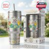 A stainless steel Pokemon tumbler with anniversary artwork stands next to its packaging against a bright garden background!
