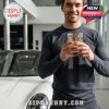 A man stands in front of a white Porsche car at a dealership while holding a golden-detailed Porsche 95th Anniversary glass!