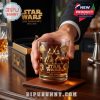 Golden Star Wars 50th Anniversary whiskey glass held by a hand, featuring detailed engravings of classic characters and spaceships with a premium box in the background!