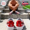 Male model on stadium stairs wearing Utah Utes Champions sneakers in red and white with visible back heel branding and school logo!