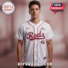 White baseball jersey featuring 'Reds' in script, 'The Romantic' text, and a Reds logo patch!