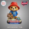 Paddington Bear figure with red hat, blue coat and suitcase. Text reads 'Paddington off to London!' and '70 years'.!