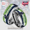 Close-up of two silver rings. The outside of the rings feature Super Bowl LX Champions Seattle Seahawks design.!