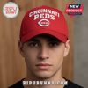 Man wears a red cap with 'Cincinnati Reds' text and logo.!
