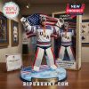 Connor Hellebuyck 2026 figurine wearing USA jersey and gold medal with a USA flag backdrop, displayed in box.!