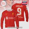 Red Liverpool sweatshirt. 'DARWIN 9' text. Standard Chartered logo. LFC emblem. Unique soccer fan merch!