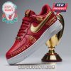 Red and gold sneaker with Liverpool F.C. logos and 'Champions 2024/25' text, next to a trophy.!