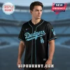 Black baseball jersey with light blue 'Dodgers' script text, LA logo on front and sleeve, and light blue piping details!