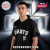 A black baseball jersey with white GIANTS text, an SF logo, and a white geometric spider design on the sleeve!
