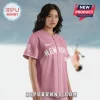 A pink button-up baseball jersey with white piping and the text 'NEW YORK' in white across the chest and a swoosh logo!