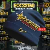 Dark blue knit beanie featuring large yellow gold Rockstar Energy Drink logo with star, red ENERGY DRINK text, and gold Nike swoosh!