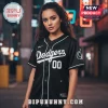 A black baseball jersey with white script text reading 'Dodgers' and the number '00' on the front, worn by a woman!