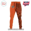 Orange split-design joggers with a tiger head logo on one leg and a brown Aboriginal-style dot art pattern on the other!