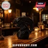 Black ceramic alien xenomorph head liquor decanter on a wooden bar top with dim restaurant lighting background!