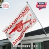 White Arsenal FC flag with red cannon logo and Champions 25/26 text flying on a metal pole against a house roof!