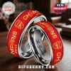 Red and silver Arsenal Champions 25/26 rings with cannon emblem and engraved text on a wooden table!