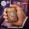Gold lighter with BTS Cosmic Friends character engraving and purple accents on a purple velvet box background!