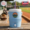 A blue cooler cup sitting on a bench with a baseball field background!