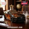 Black sports car whiskey decanter with gold crown topper on a wooden desk with keys and glass!