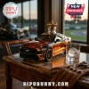 Mustang car shaped liquor decanter with gold crown topper, glass with ice sphere, and brown leather gloves on marble table!