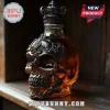 Decorative skull-shaped liquor glass decanter with ornate black metal filigree detail on a wooden shelf!