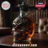 Glass skull decanter with ornate silver metal filigree and crown stopper filled with amber whiskey on wooden desk!