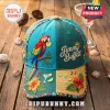 Teal and yellow cap with embroidered parrot, lime, hibiscus flowers, and Jimmy Buffett text on wooden background!