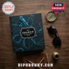 An overhead view of a black gift box with a blue octopus design alongside a compass sunglasses and a pen on a wooden table!