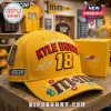 Yellow NASCAR cap featuring Kyle Busch 18 branding, M and M logo, and embroidered autograph on a wooden shelf!