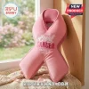Pink ribbon shaped throw pillow with embroidered Breast Cancer Awareness Month text on a knit blanket near a window!