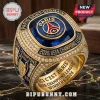 Gold championship ring with blue gem, PSG logo, and text Paris Saint-Germain 2026 UEFA Champions League on dark surface!