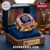 Gold Paris Saint-Germain 2026 UEFA Champions ring with blue gemstone, diamond accents, and team logos in a display case!