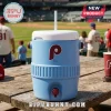 A light blue water jug with a straw on a wooden table with a baseball field in the background!