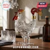Clear glass rooster decanter with red and amber accents on a wooden dining table!