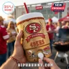 A person holding a gold San Francisco 49ers anniversary cooler cup at a stadium tailgate party!
