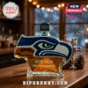 Seahawks logo shaped glass whiskey bottle with 1976-2026 50th Anniversary text on a wooden bar top background!