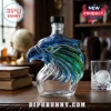 Clear glass decanter shaped like an eagle head with blue and green highlights on a wooden table!