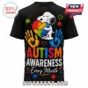 Black t-shirt featuring Snoopy holding a rainbow puzzle heart with colorful handprints and Autism Awareness text graphics!