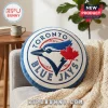 Round Toronto Blue Jays baseball team logo pillow in white and blue featuring a red maple leaf on a grey sofa!