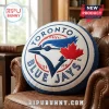 Round plush Toronto Blue Jays baseball pillow with blue and red team logo on white background sitting on leather chair!